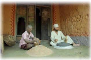 Shri Sai grinding grain with a stone grinder